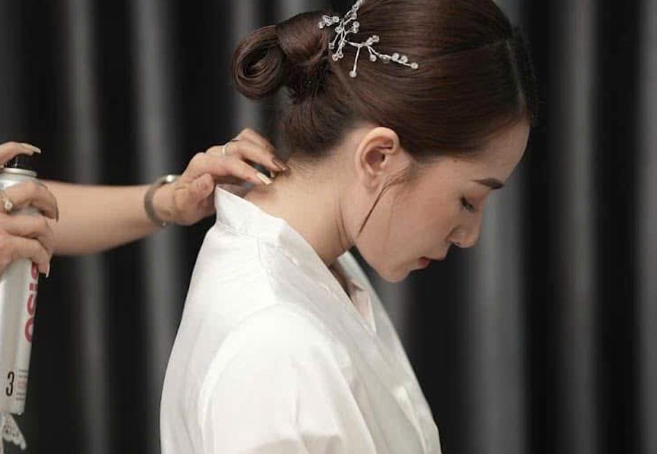 Thợ của Makeup Kiều Min xịt giữ nếp tóc cho cô dâu trước giờ lễ