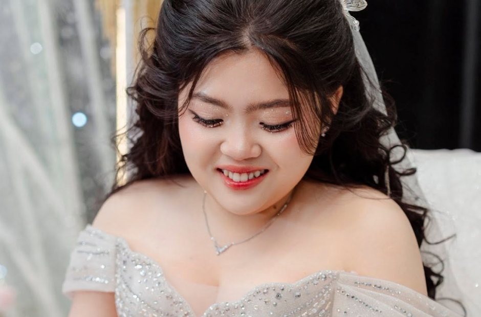 Cô dâu váy cưới ôm hoa, cười tươi trong ngày cưới