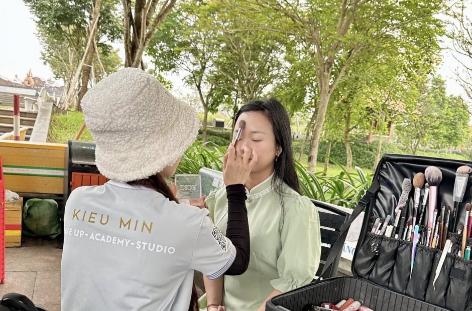 Thợ trang điểm cho khách ngoài trời, cốp đồ nghề mở bên cạnh