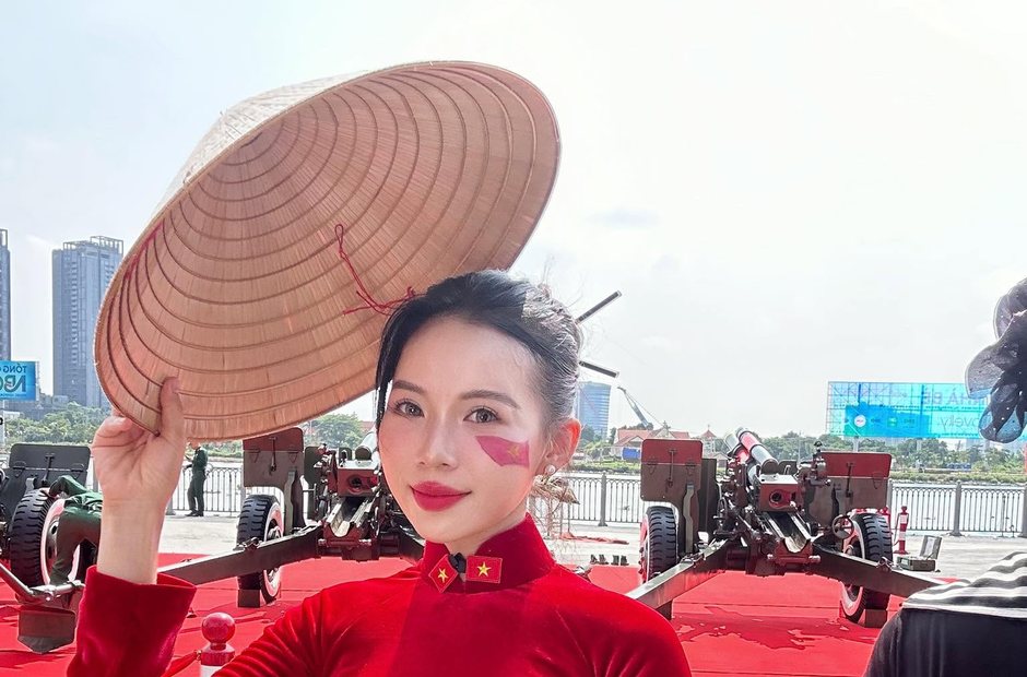 Bạn nữ áo dài đỏ cầm nón lá chụp ngoài trời nắng