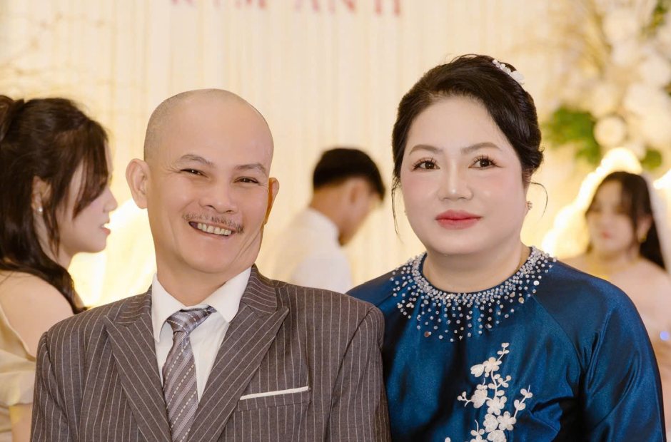 Bố mẹ chụp chung trong tiệc cưới, mẹ mặc áo dài xanh đậm trang điểm nhẹ