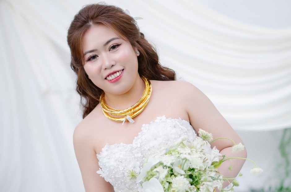 Cô dâu cầm hoa trước phông trắng với lớp nền mềm