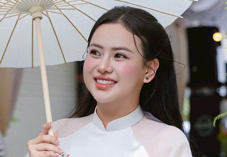 Cô dâu mặc áo dài trắng cầm dù trong lễ cưới truyền thống