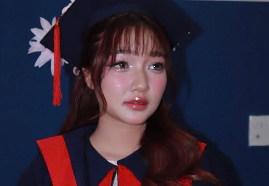 Bạn nữ mặc lễ phục tốt nghiệp sau buổi trang điểm kỷ yếu