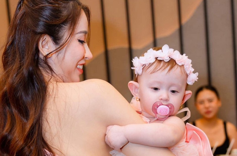 Mẹ bế con trong một buổi tiệc