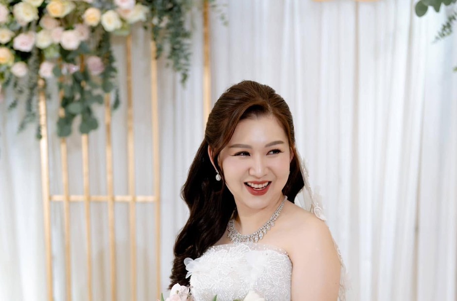 Cô dâu mặc váy xòe trước phông hoa cưới